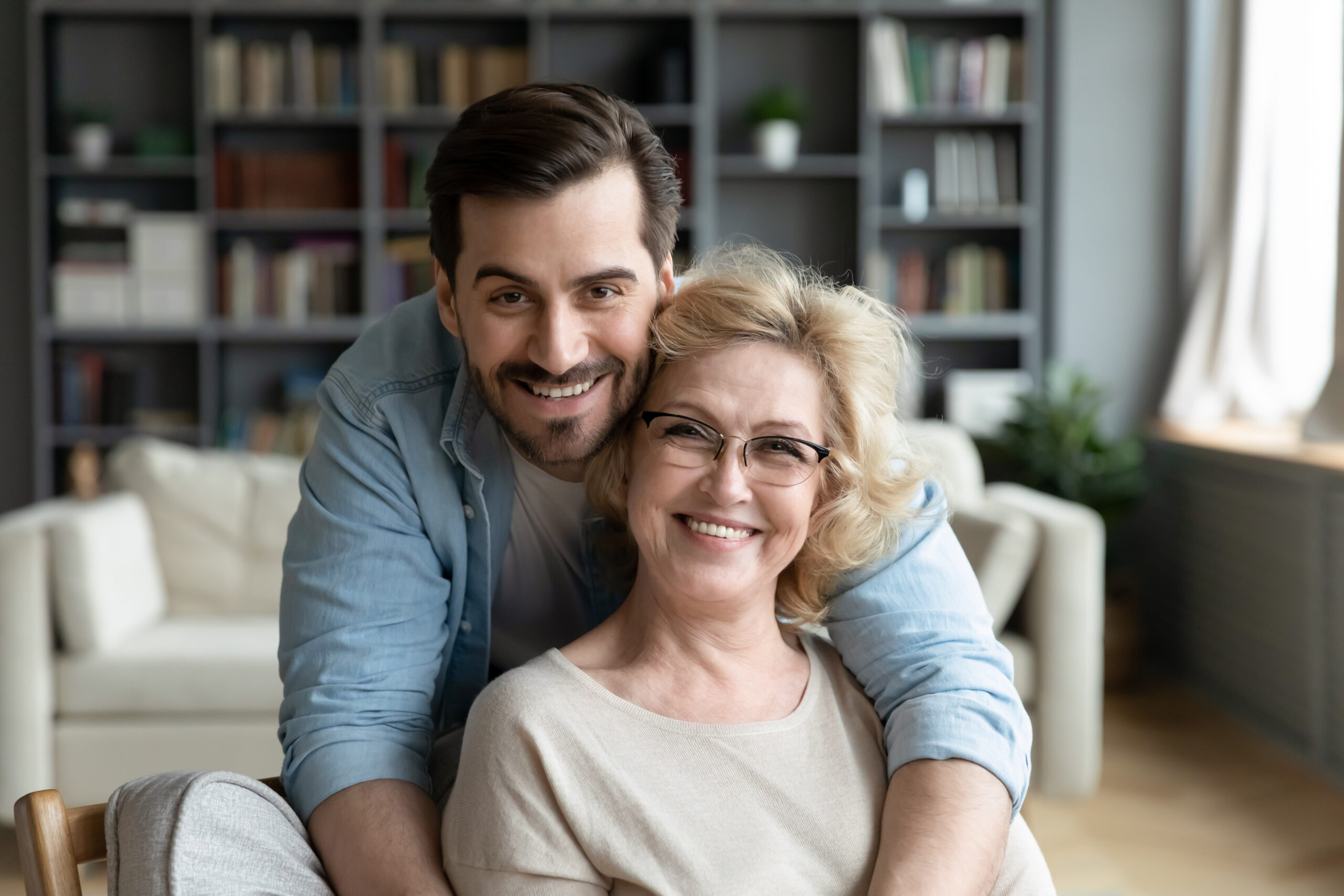 2 family members sit in living room happily