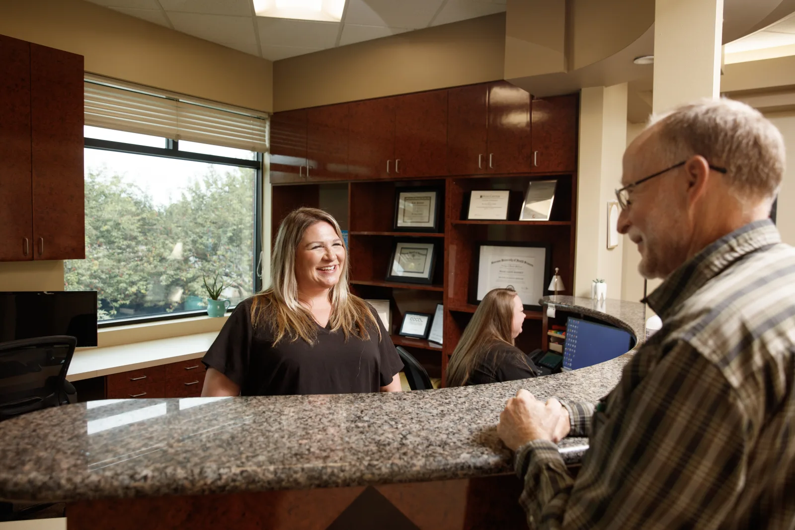 Gresham Advanced Dentistry – Front Desk Checkout Patient speaking with the front desk team at Gresham Advanced Dentistry