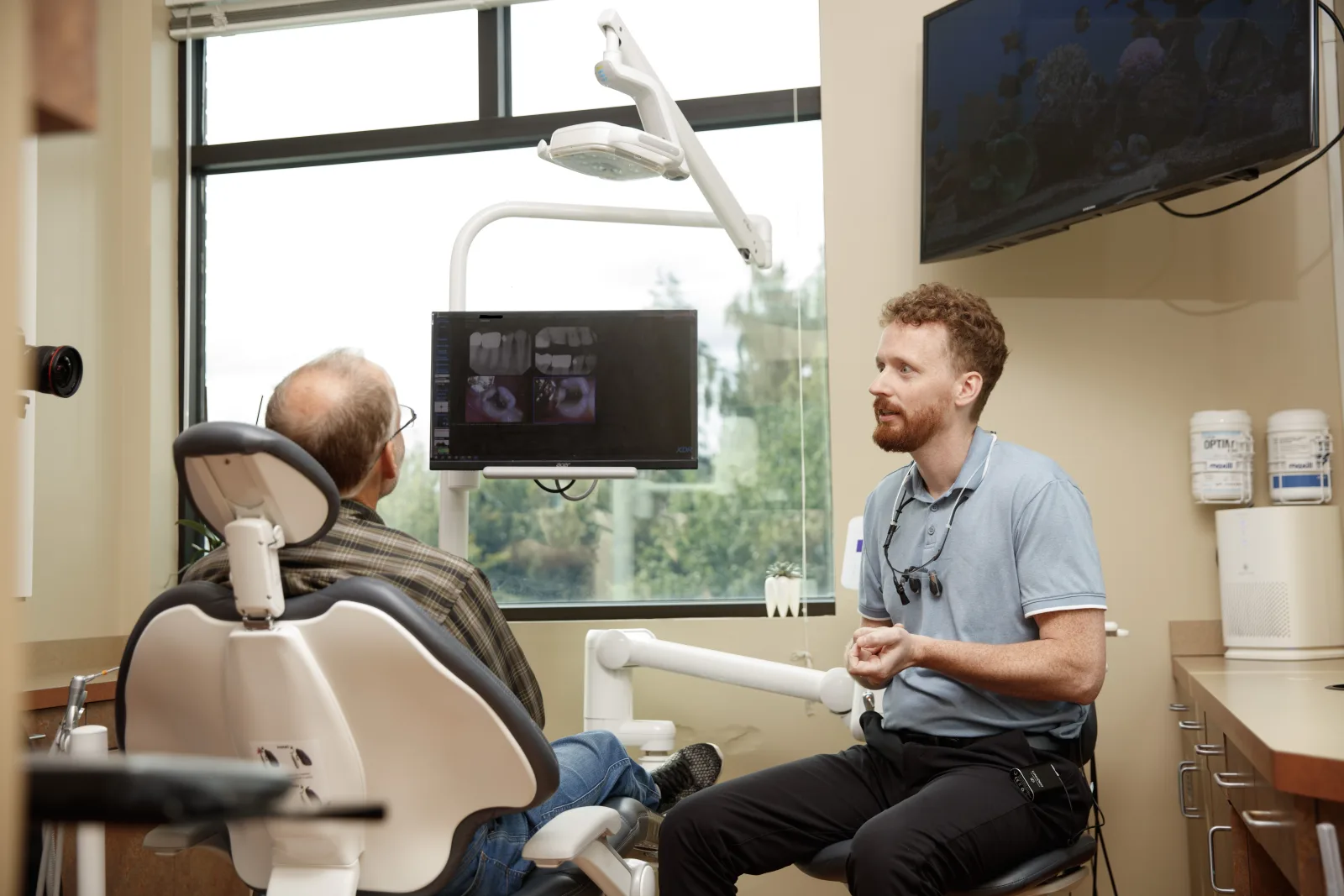 Gresham Advanced Dentistry – Presenting Findings Dentist reviewing digital findings with a patient at Gresham Advanced Dentistry
