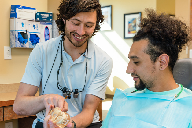 Gresham Advanced Dentistry – Dentist Explaining Treatment Dentist explaining treatment options to a patient at Gresham Advanced Dentistry in Gresham, OR