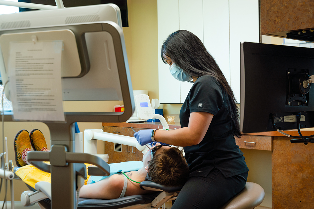 Gresham Advanced Dentistry – Office Tour 9 Dental hygienist caring for a patient at Gresham Advanced Dentistry in Gresham, OR