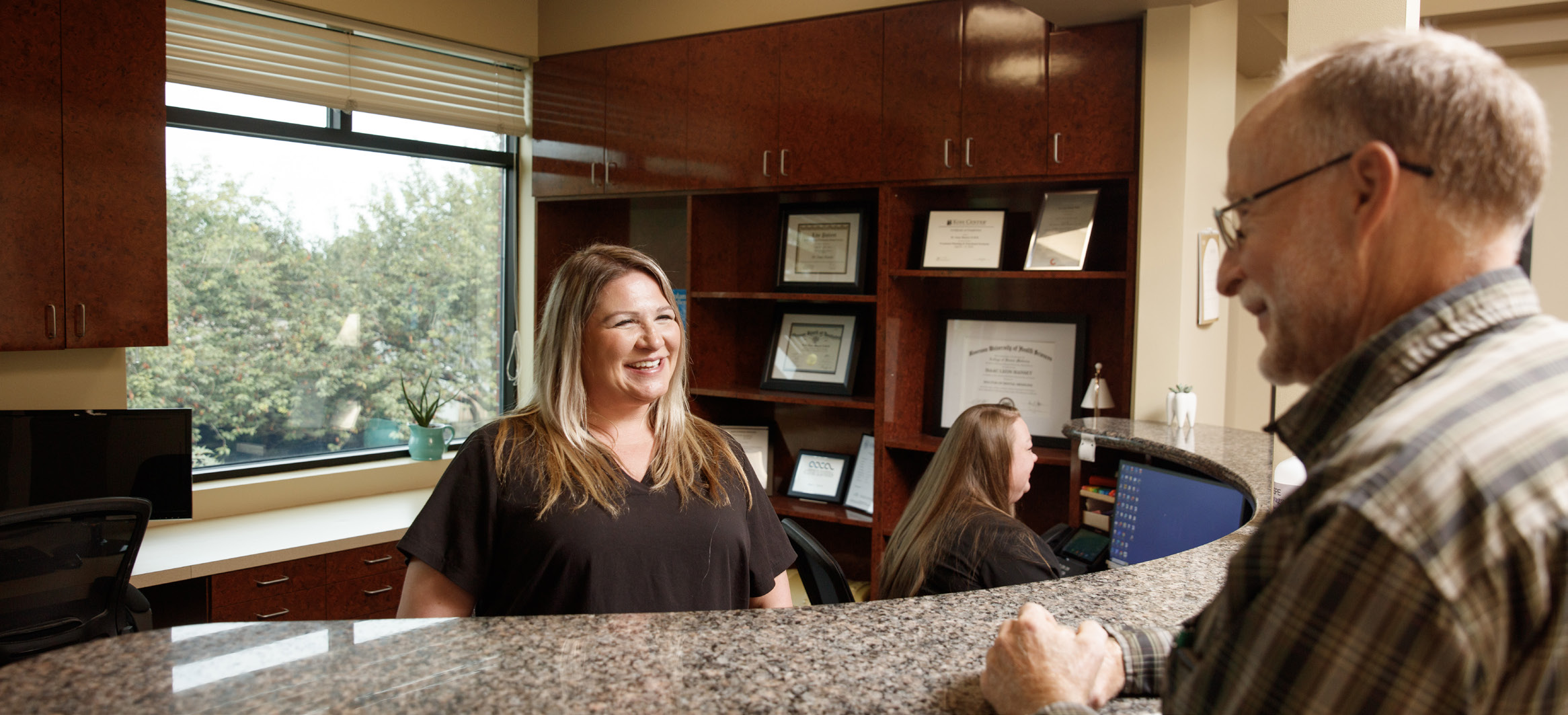 Gresham Advanced Dentistry team member welcoming a patient at the front desk