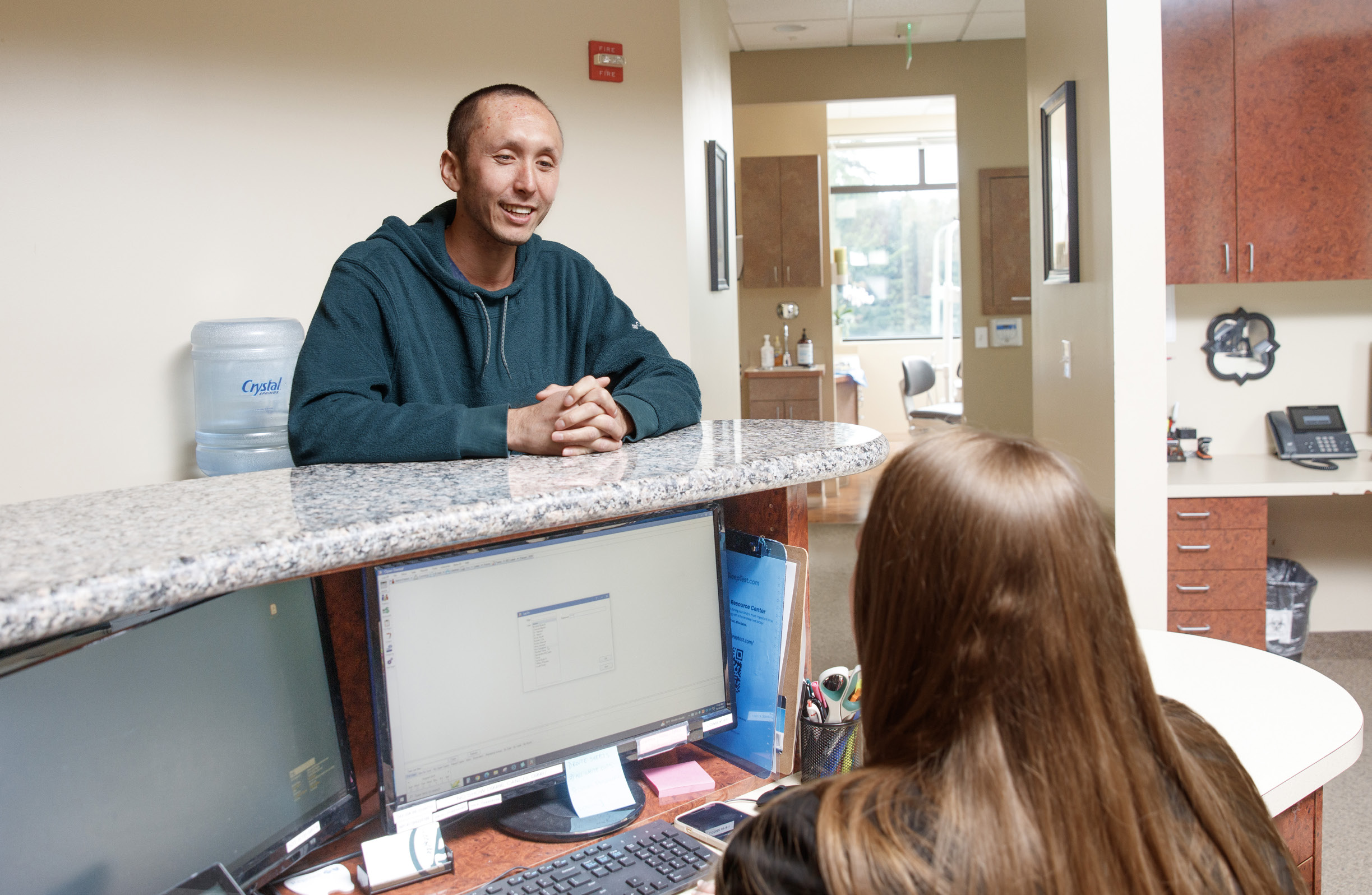 Patient checking in with a team member at the front desk